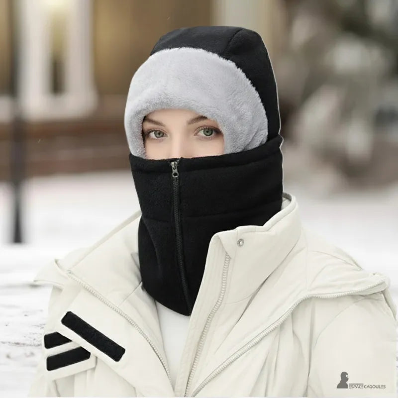Cagoule femme polaire a zip frontal noire portée par une femme en manteau d’hiver blanc sur fond de neige - Espace Cagoules