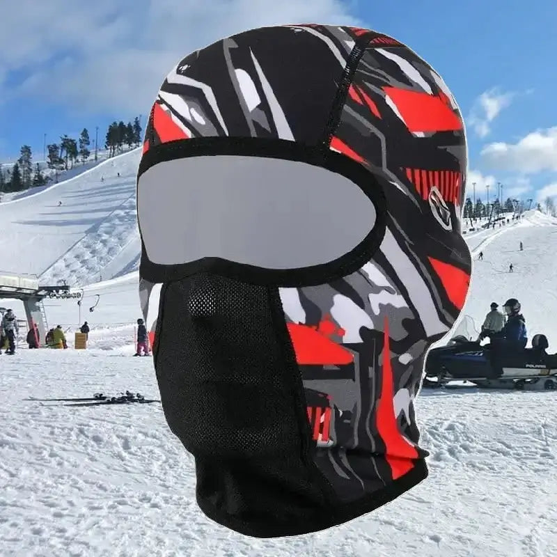 Red patterned ski helmet hood, worn on a snowy slope in a ski resort, protecting the face from the cold.