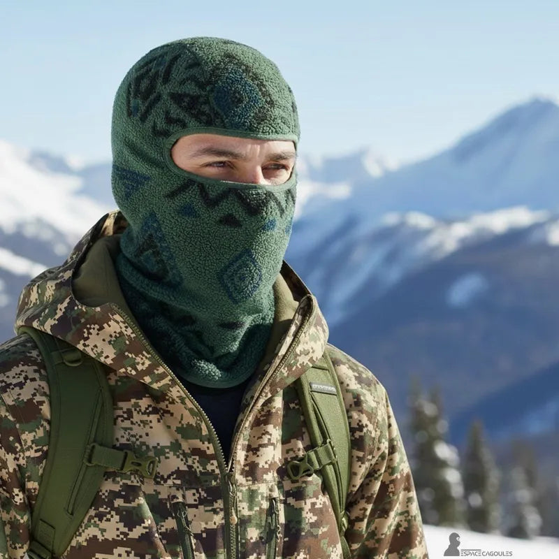 Green ski hood worn by a man in a mountain environment with a backpack, showcasing a thick fleece and protection against wind and cold - Space Hoods.
