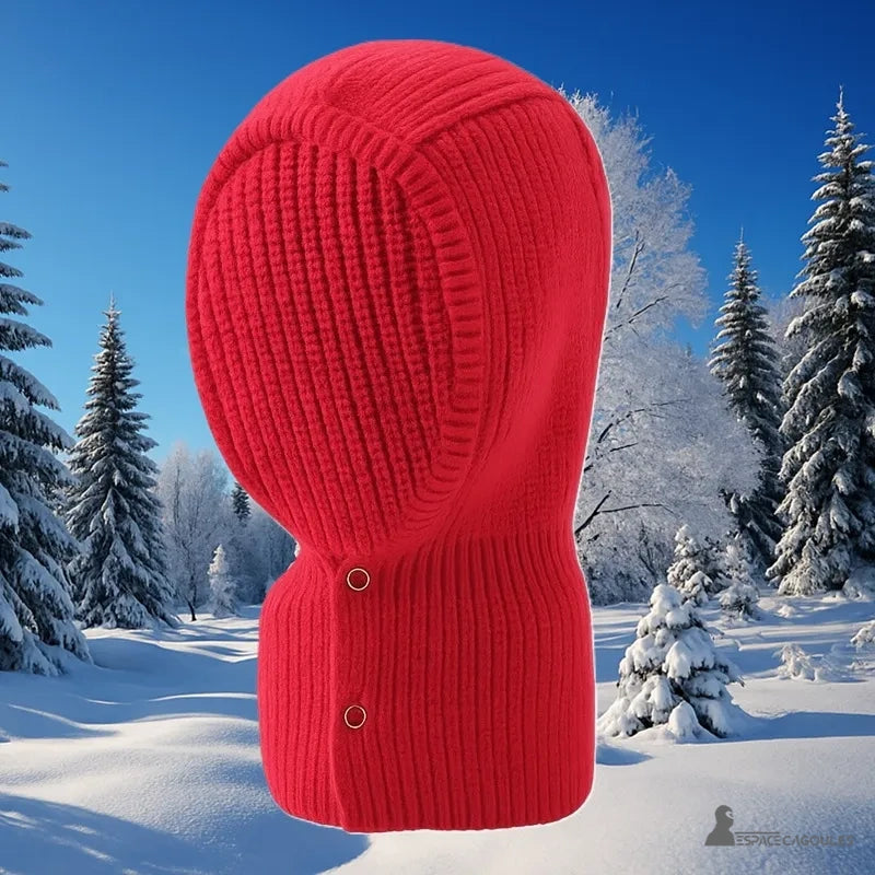 Cagoule Rouge en maille épaisse photographiée en extérieur sur fond de forêt enneigée, parfaite pour l’hiver