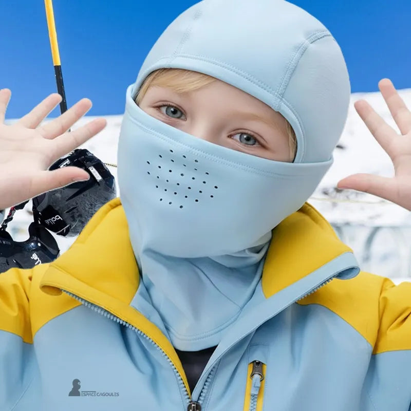 Skidbalaclava i blĂ„ fleece för barn som bĂ€rs av ett leende barn i de snöiga backarna, gul och blĂ„ jacka â Espace Cagoules