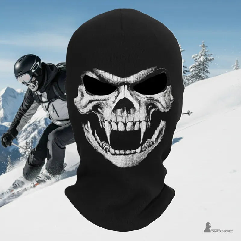Cagoule ski tĂȘte de mort noire avec motif crĂąne blanc portĂ©e en pleine descente enneigĂ©e par skieur casquĂ©, Espace Cagoules