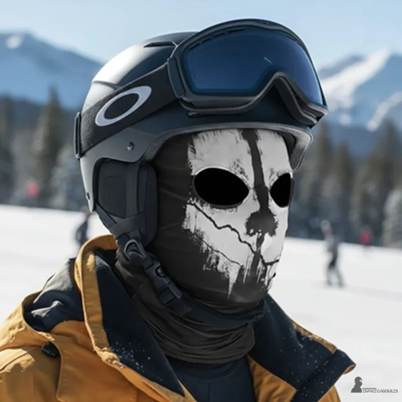 Black Skull balaclava worn with a ski helmet and goggles on a snowy mountain slope, front view – Cagoules Space