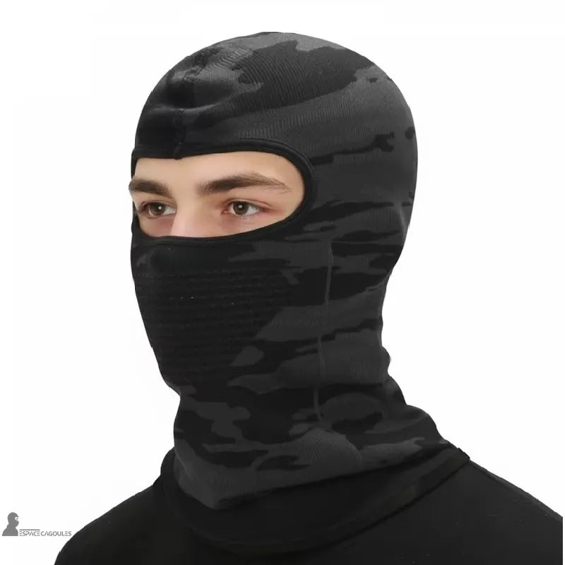 Cagoule sous casque en polyester et spandex de couleur noire, forme ajustée avec une ouverture pour les yeux, vue portée sur fond neutre - Espace Cagoules