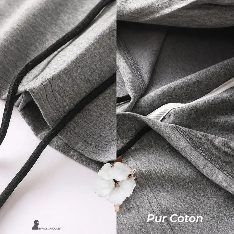 Cagoule streetwear grise en coton pur, vue rapprochée sur la texture du tissu avec symbole coton, soulignant qualité naturelle et respirabilité
