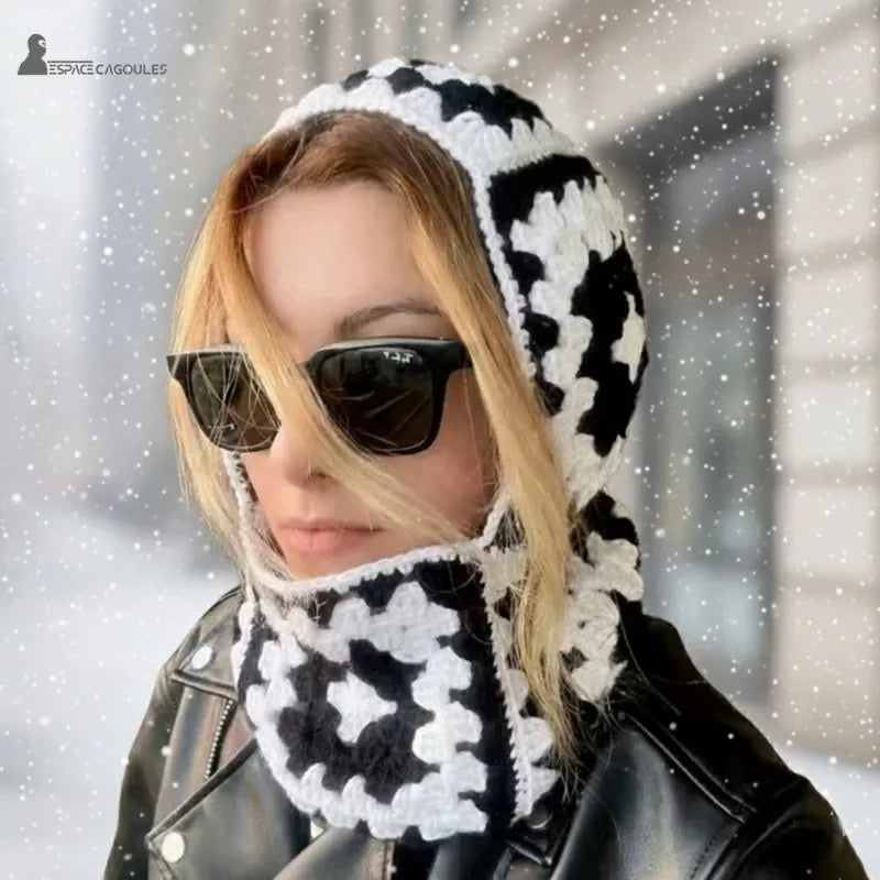 Black and white crochet women's balaclava worn in town with a black jacket and loose hair