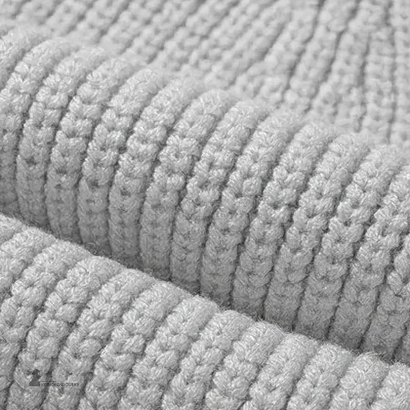 Cagoule tricot enfant gros plan texture laine grise, détails des mailles épaisses pour chaleur hivernale