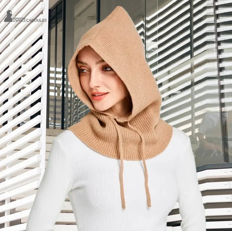 Camel color women's knitted balaclava worn in modern interior with natural light and white architectural background