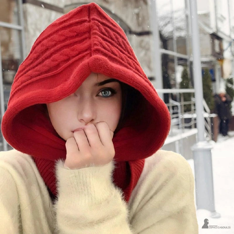 Passamontagna con cappuccio Rosso, lavorato in lana spessa indossata da una donna in una strada innevata, calore ed eleganza invernale