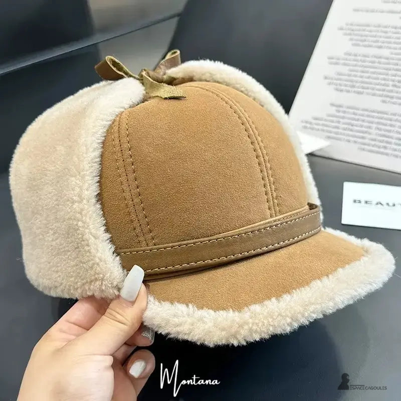 Beige keps sedd framifrån med styv skärm och shearlingkanter i ull