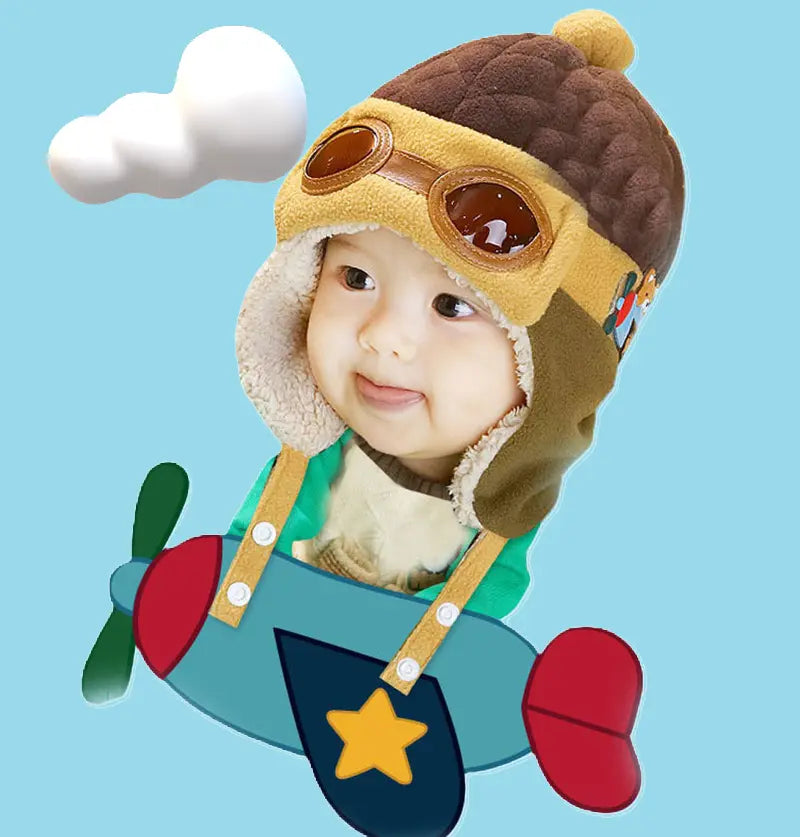 Brown aviator child hat with integrated glasses, worn by a child on a blue background with elements of clouds and airplane.