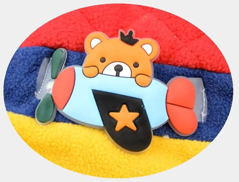 Detail of the decoration on a colorful aviator children's hat, with a little pilot fox and a red and yellow background.