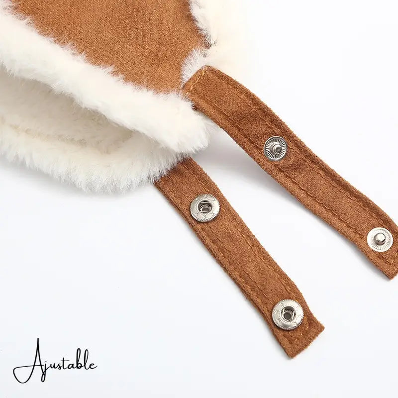 Close-up of the adjustable straps of a children's hat in brown suede with snap buttons. Secure closure system for optimal protection against the cold.