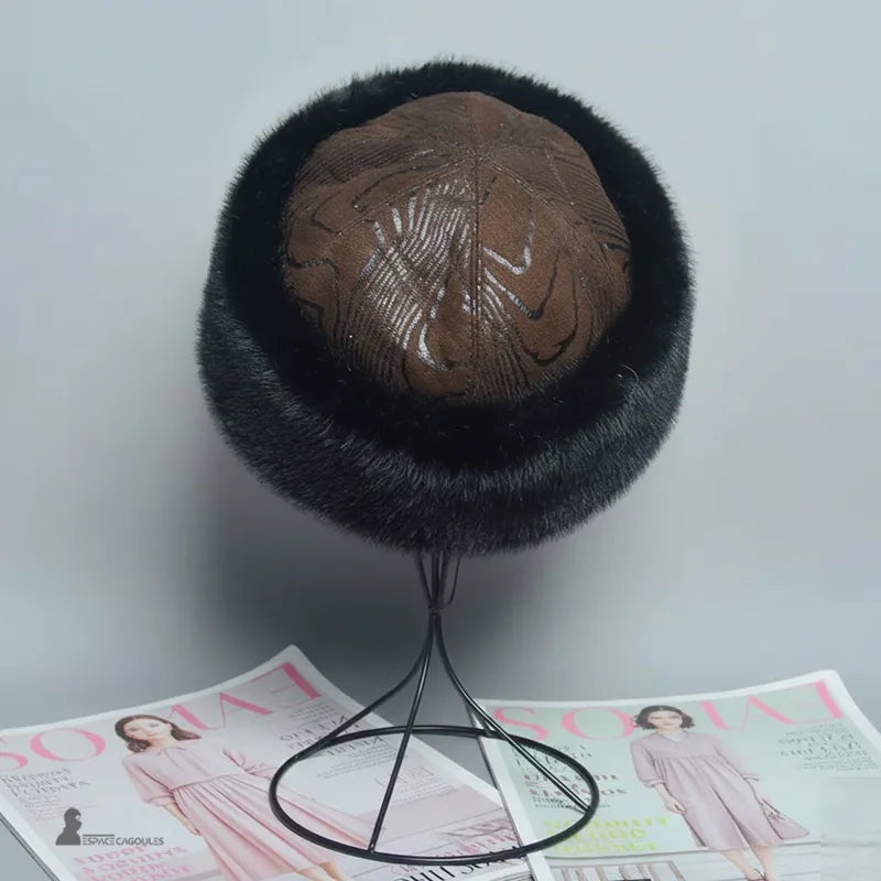 Faux fourrure Chapka in schwarzer Kunstfell mit braunem Oberteil, runde Chapka-Form, von oben auf einem Ständer präsentiert, in einem hellen Innenraum - Cagoules Raum.