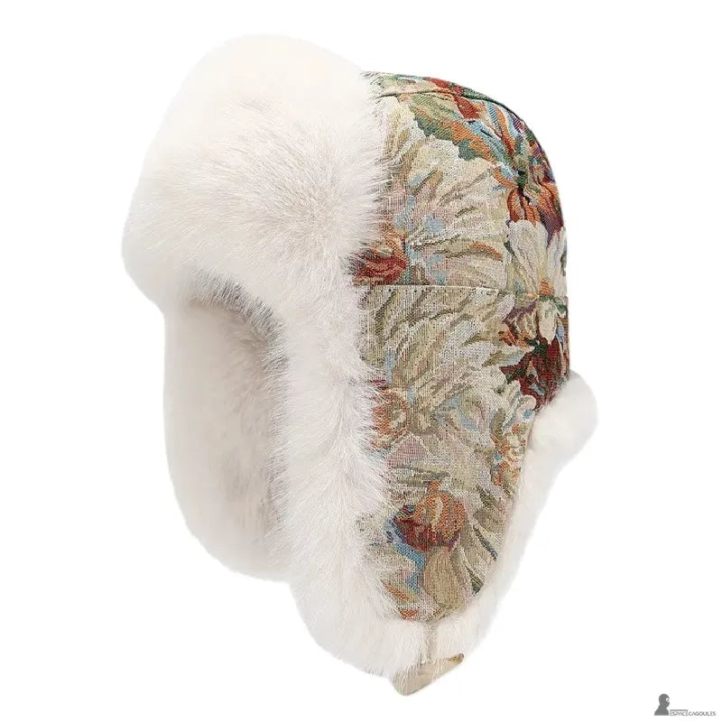 Vue de profil d’une chapka à motif floral beige avec fourrure blanche et attache sous le menton - Espace Cagoules