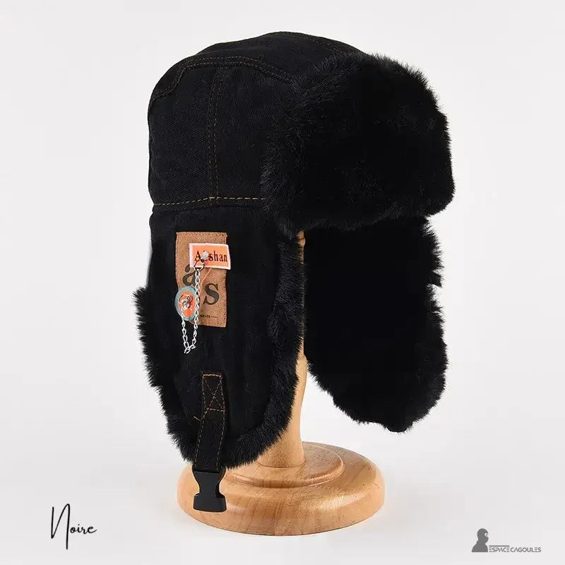 Black winter women's hat with thick fur exposed on wooden stand