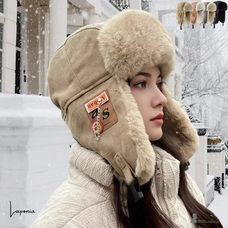 Women's beige winter faux fur hat worn by a woman outdoors in the snow