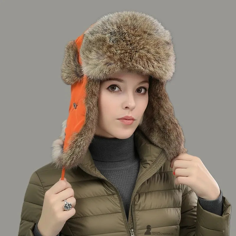 Cappello di pelliccia femminile – Donna che indossa un cappello di pelliccia di coniglio arancione con giacca di piume kaki, look invernale moderno – Espace Cagoules