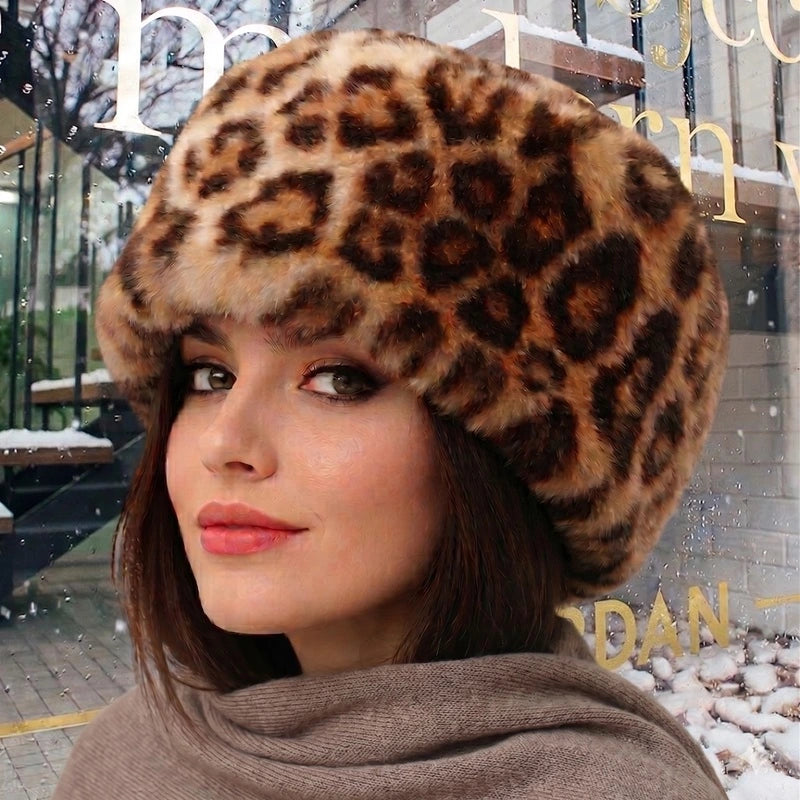 Leopard fur-effect hat with feline patterns, worn outdoors on a mannequin. A warm and stylish winter accessory for cold days.