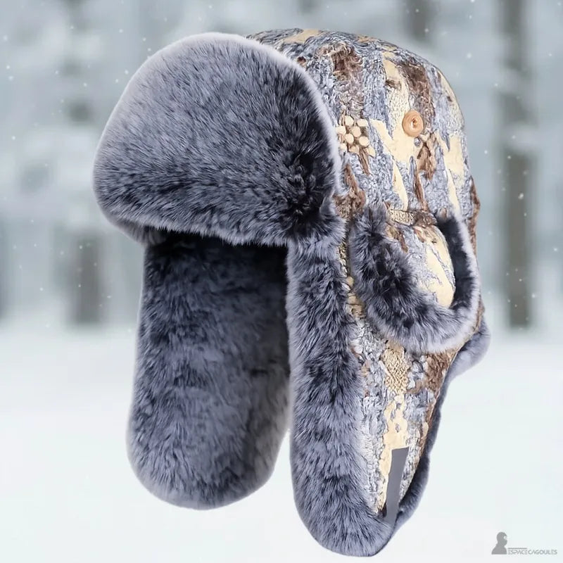 La Chapka patchwork fourrure présentée seule en lévitation sur fond de forêt enneigée floue - Espace Cagoules