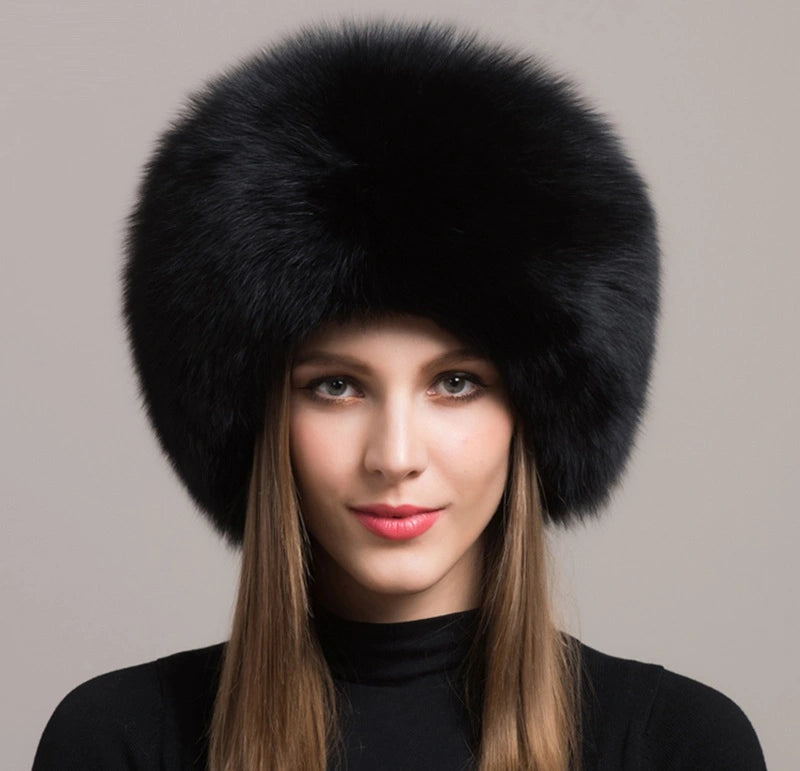 Elegante Frau trägt eine russische Chapka aus echtem schwarzem Pelz, mit luxuriösem Finish und beeindruckendem Volumen. Ideal für den Winter und eisige Temperaturen, bietet diese Chakka Wärme und Raffinesse.
