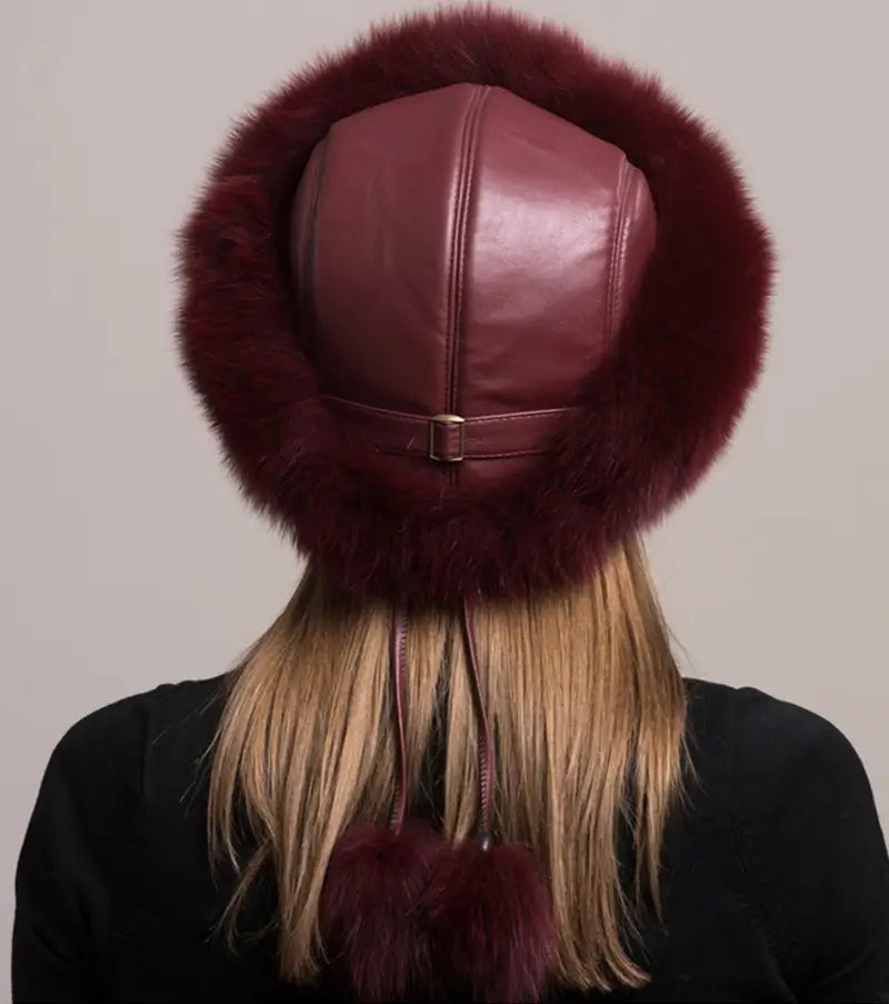 Rückansicht einer russischen Chapka aus echtem burgunderrotem Fell, mit einem weichen Ledersockel und einem passenden Bommel. Sein umlaufendes Design sorgt für Wärme und Eleganz im Winter.