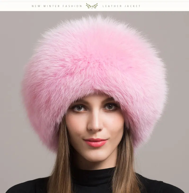 Elegante Frau trägt eine russische Chapka aus echtem rosa Pelz, mit großzügigem Volumen und seidiger Textur. Ein raffiniertes Winteraccessoire, das sich perfekt eignet, um Wärme und Eleganz mit einem Hauch von femininer Weichheit zu verbinden.