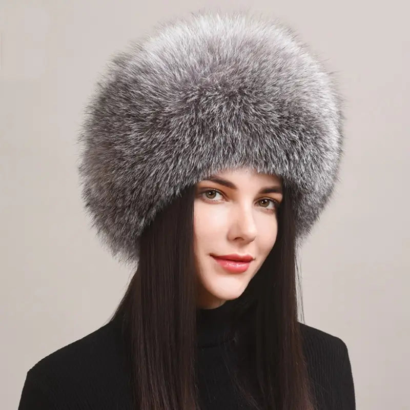 Elegante Frau trägt eine russische Chapka aus silberblauem Echtpelz, voluminös und raffiniert. Ein luxuriöses Winteraccessoire, das sich perfekt eignet, um Wärme und Eleganz mit einem raffinierten Touch zu verbinden.