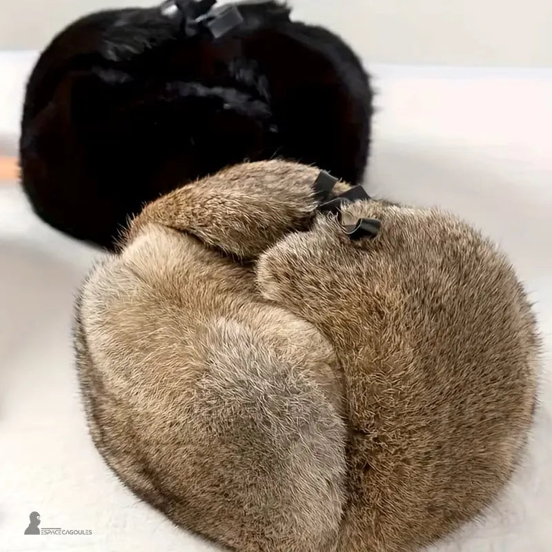 Chapkas Russes pour homme brune et noire en fourrure posées sur surface blanche