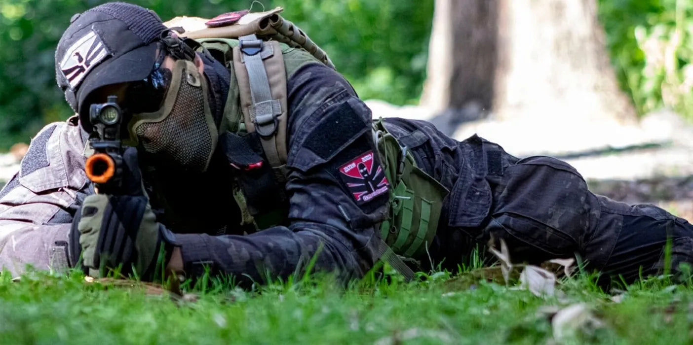 Cagoule Airsoft tactique beige portée par un joueur allongé en action sur le terrain