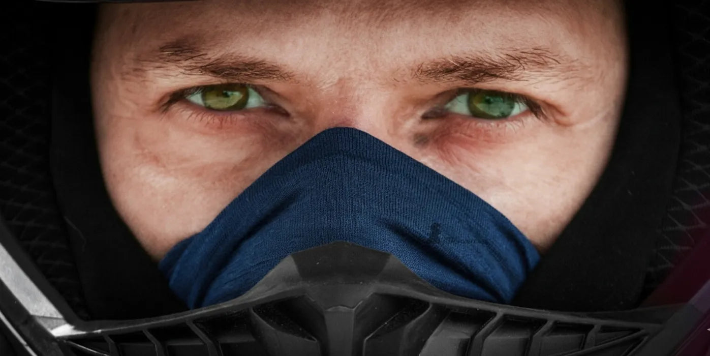 Cagoule moto bleue ajustée sous un casque intégral, gros plan sur le regard d’un motard aux yeux verts concentré sur la route – Cagoule Moto - Espace Cagoules