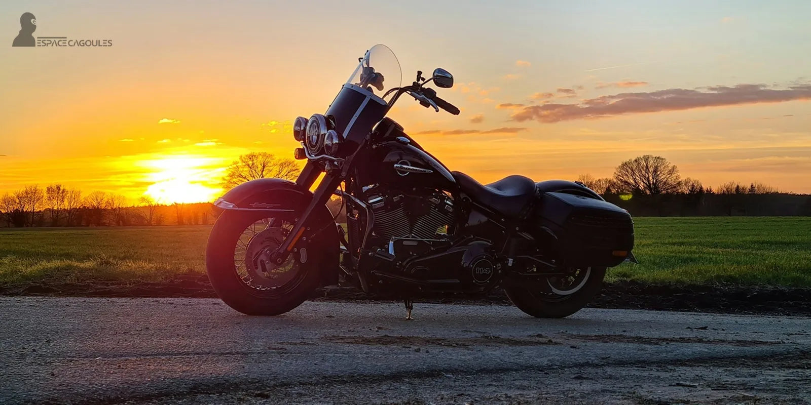 Cagoule Moto Été – Moto noire garée sur route au coucher du soleil, évoquant liberté, confort et protection pour motards en été