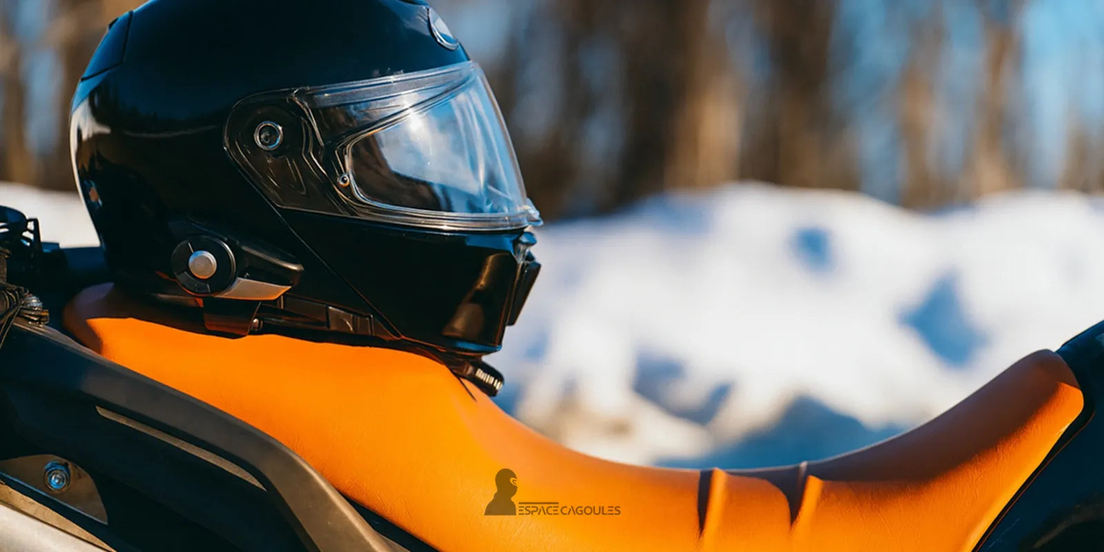 Cagoule Moto Hiver – Casque noir sur selle orange de moto, symbolisant chaleur, performance et protection contre le vent glacial
