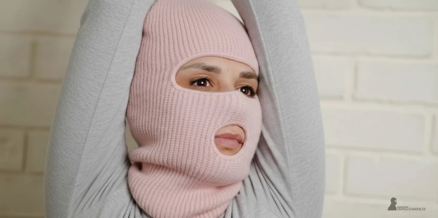 Femme en tenue d’hiver grise portant une cagoule rose claire à trois ouvertures, modèle chaud et confortable pour les journées froides – collection Espace Cagoules