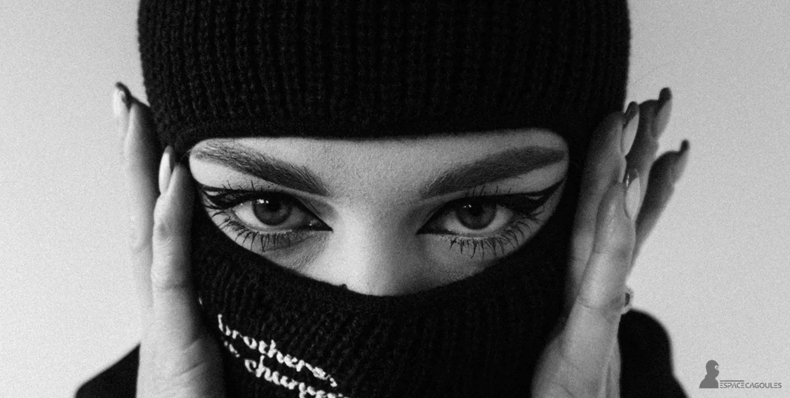 Cagoule Noire femme gros plan sur les yeux maquillés, matière tricot épaisse, ambiance noir et blanc – visuel Espace Cagoules