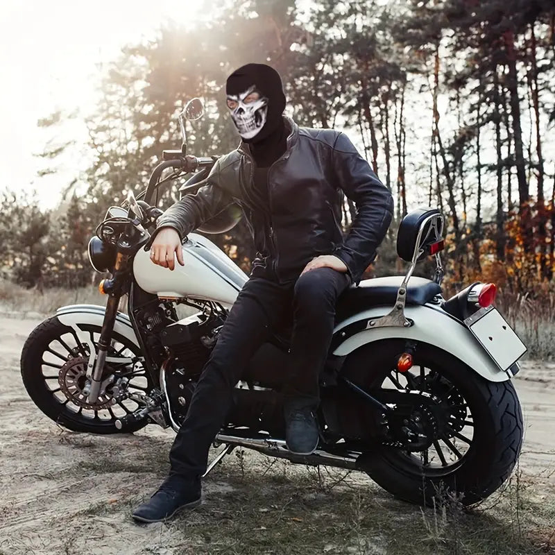 Motard portant une Ghost MW2 Cagoule avec design tête de mort, assis sur une moto blanche dans un cadre forestier automnal