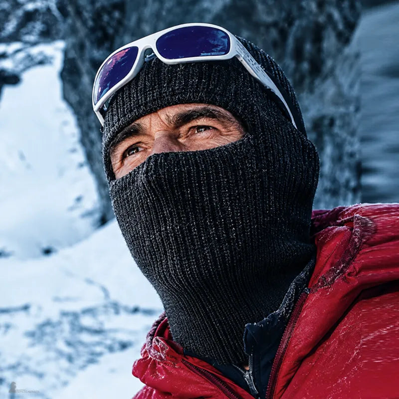 Homme en montagne enneigée portant la cagoule DuoPeak déployée sur le visage sous grand froid - Espace Cagoules