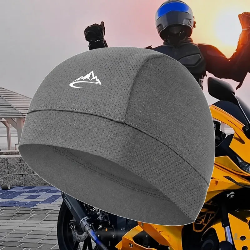 Sous-casque moto CapFlex gris posé devant un motard en tenue sur sportive jaune au coucher de soleil - Espace Cagoules