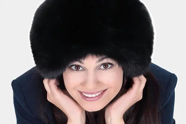 Femme souriante portant une CHAPKA en fourrure noire, accessoire élégant de la collection Chapka d'Espace Cagoules, idéale pour l'hiver et la protection contre le froid.