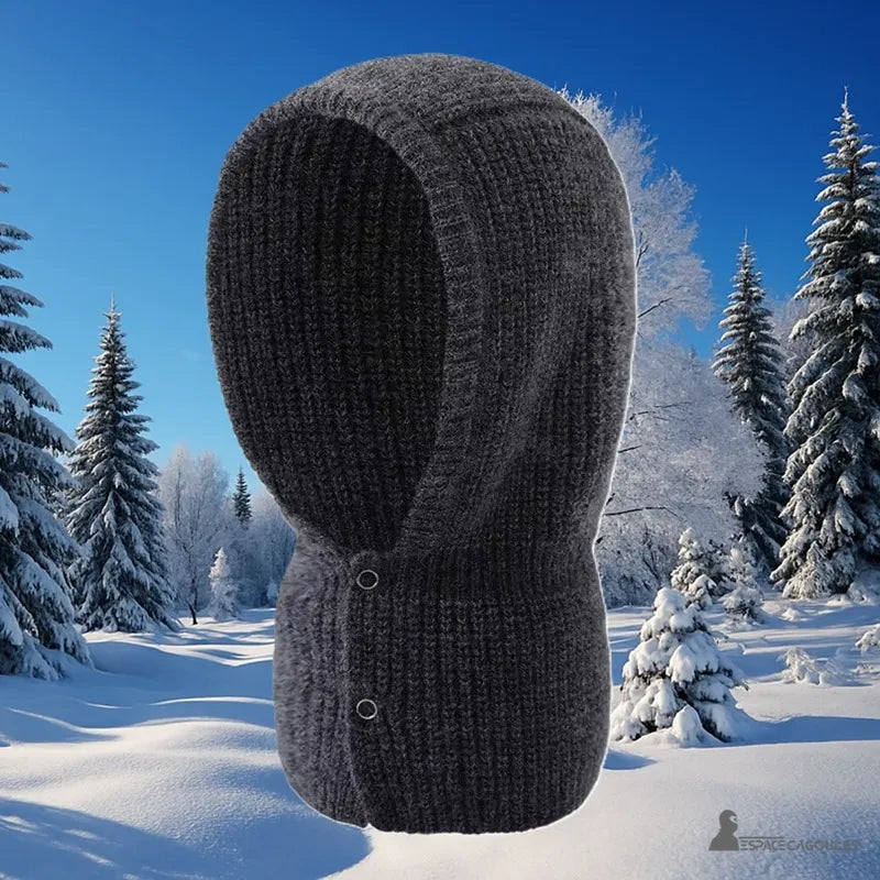 Balaclava Cagoule Tricot en laine gris foncé photographiée en extérieur sur fond de forêt enneigée par beau temps