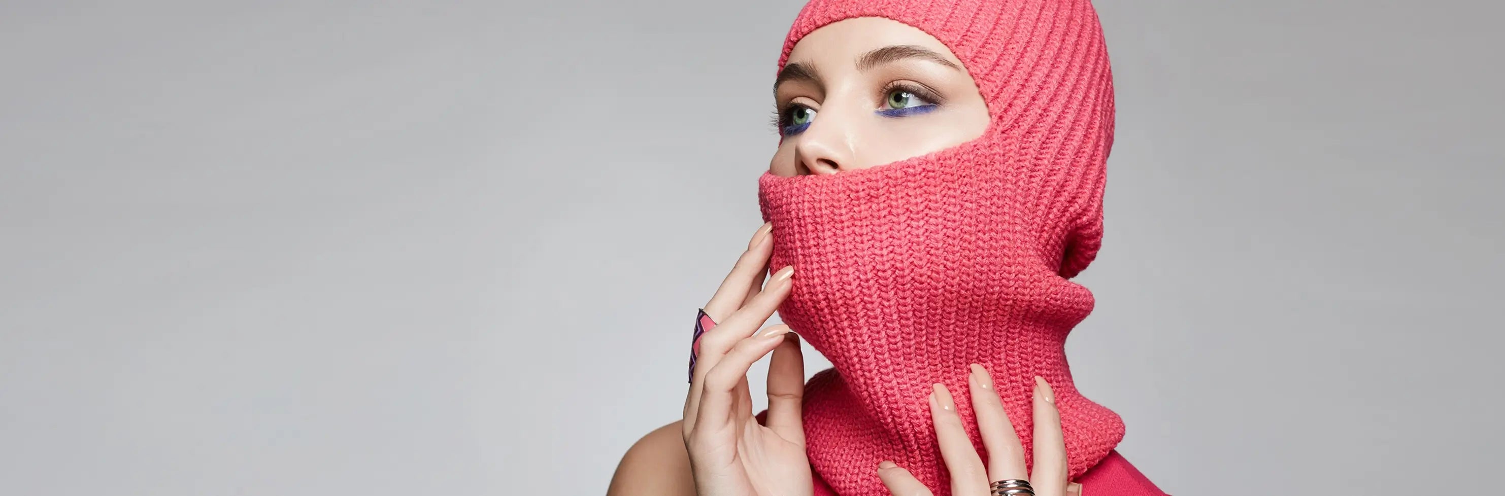 Cagoule femme – modèle en maille tricot rose vif porté par une femme, couvrant la tête et le bas du visage, mise en avant pour la collection de cagoules femme.
