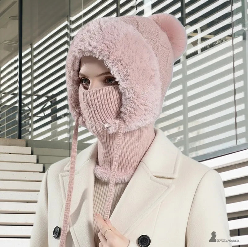 Donna con berretto a montagna rosa e kaki che indossa il berretto con passamontagna sollevato su uno sfondo interno moderno - Espace Cagoules