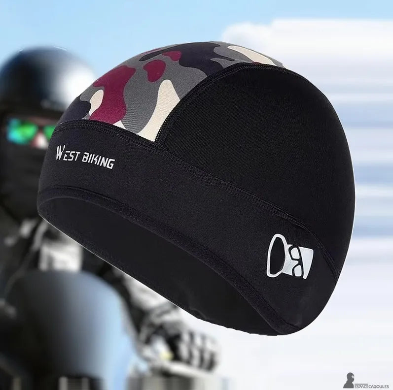 Bonnet sous casque moto noir avec panneau camouflage porté en situation devant une moto, vue trois quarts illustrant sa coupe ajustée sous casque - Espace Cagoules
