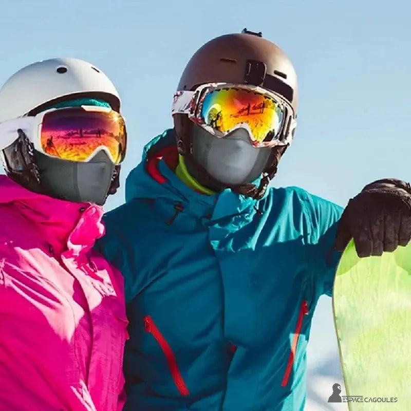 Cache cou cagoule femme et homme portés en ski, couple avec casques et masques réfléchissants sur neige ensoleillée