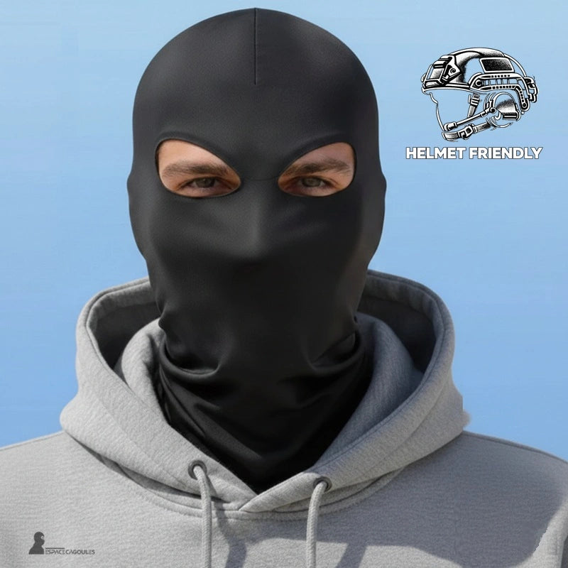 Cagoule 2 trous noire portée de face avec hoodie gris sur fond bleu uni et pictogramme casque en angle supérieur, vue portrait - Espace Cagoules