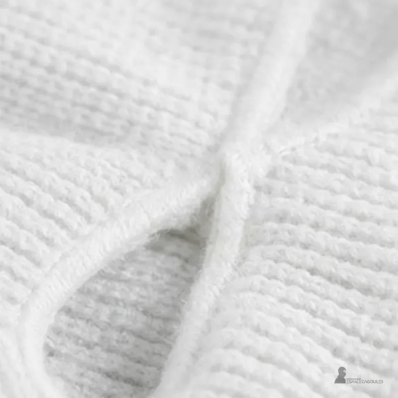 Cagoule 3 trous blanche zoomée sur le tissu en tricot épais pour mettre en avant la texture et la qualité de confection