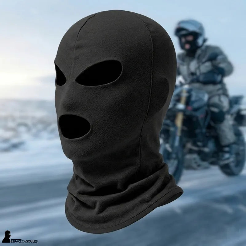 Drei-Loch-Motorradmaske in Schwarz, dreiviertel Ansicht mit Motorradfahrer im Hintergrund auf kalter Straße – Cagoule-Raum