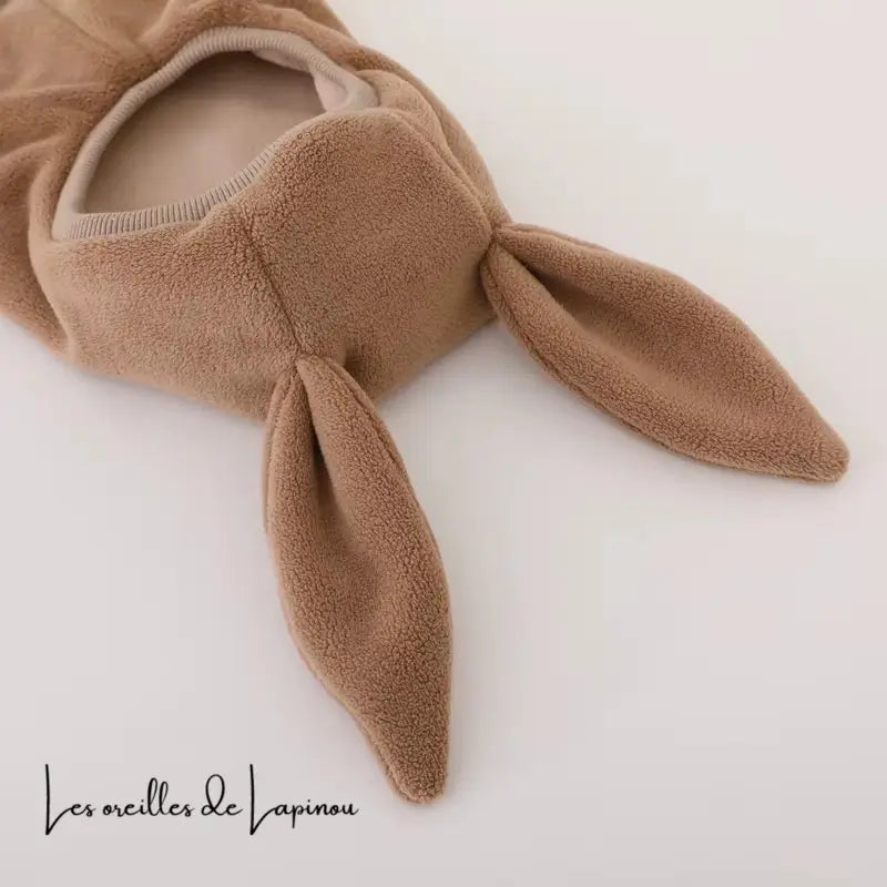Zoom sur les oreilles souples d’une cagoule bébé polaire marron, mettant en avant la douceur et l’élasticité du tissu pour un confort optimal.