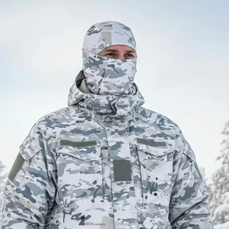 Schneetarnkappe für den Außeneinsatz im verschneiten Gelände, integriert in eine winterliche Tarnkleidung für Diskretion und Schutz gegen Kälte.
