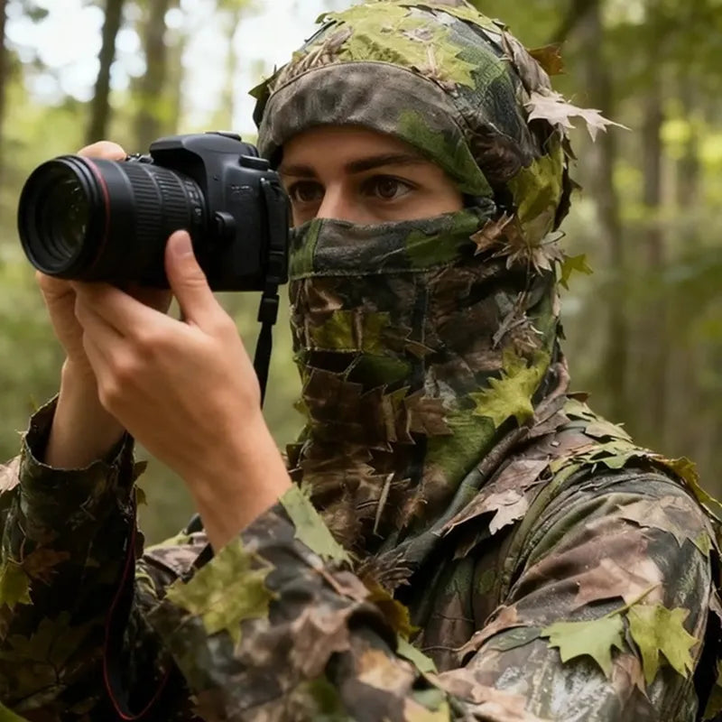 Cagoule Camouflage Photo en polyester extensible avec feuillage 3D portée en forêt lors d’une séance d’affût photographique, vue rapprochée sur le visage et l’appareil photo - Espace Cagoules